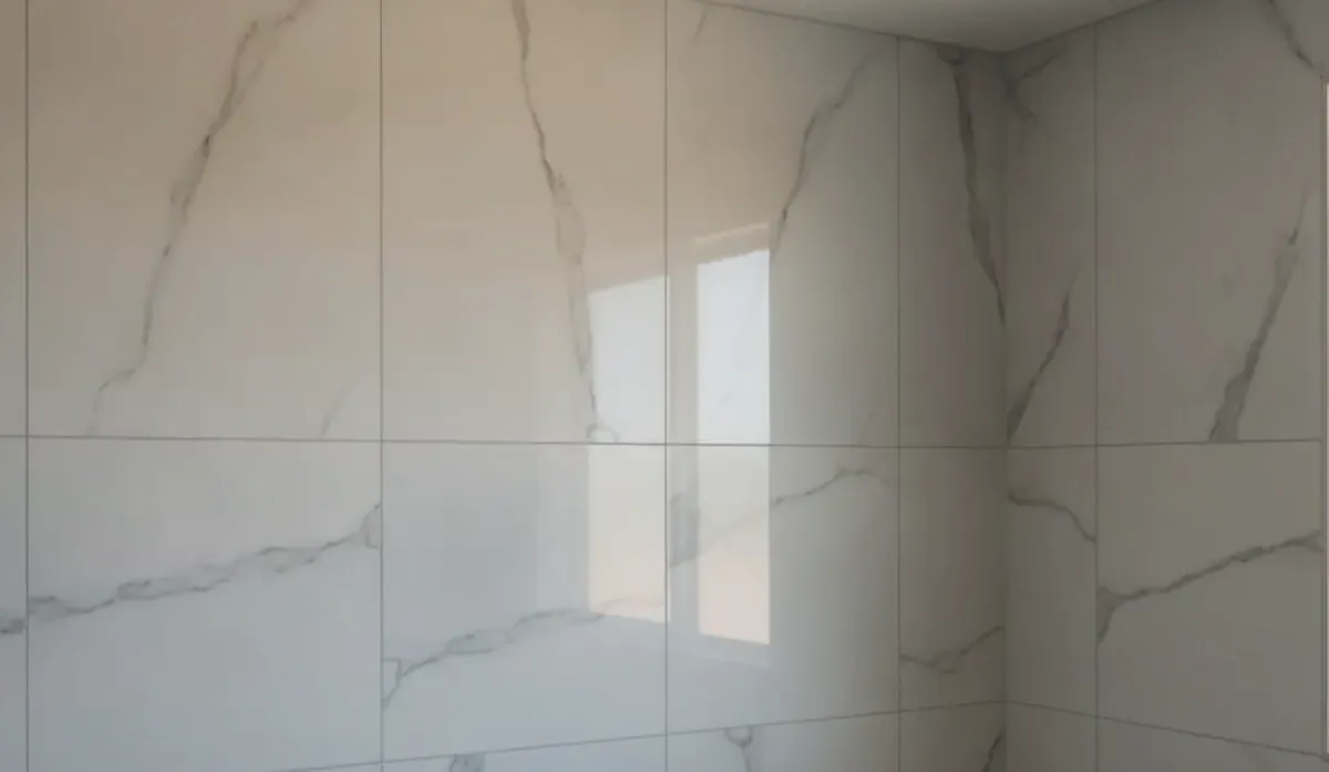 A newly installed bathroom exhaust fan mounted in a ceiling surrounded by marble-look tile in San Diego